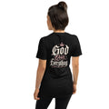 A woman shown from the back wearing a black short-sleeve t-shirt with a graphic print on the back that reads 'God Over Everything' in white and pink lettering with a small crown above the word 'God'.